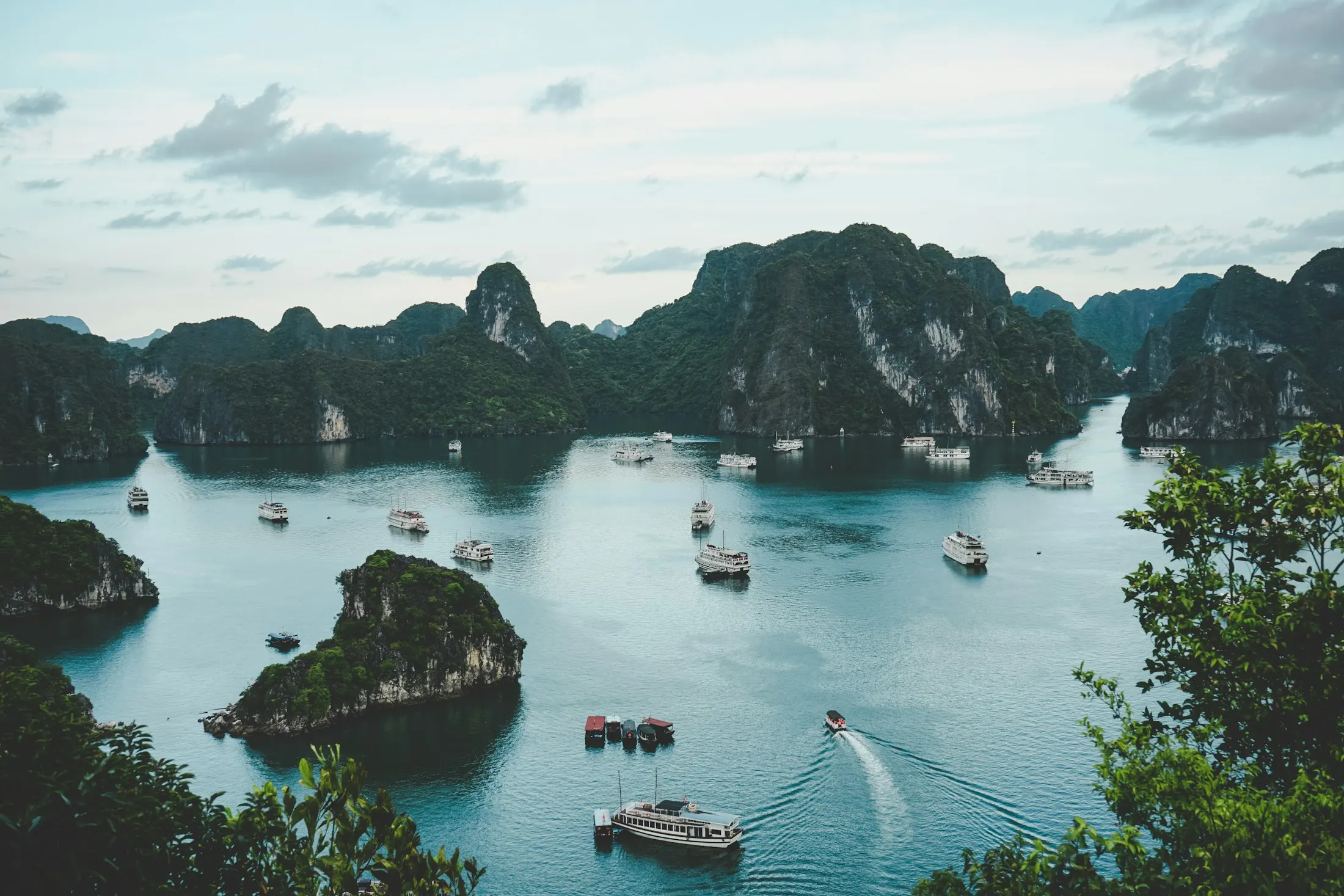 Limestone islands rising from the calm water of Ha Long Bay, Vietnam